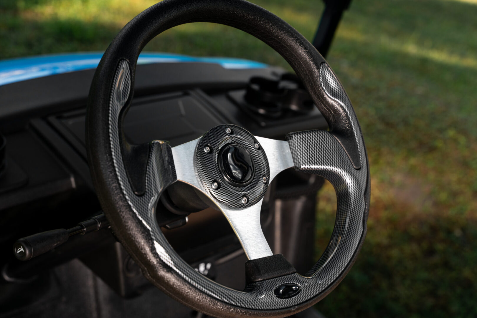 A close up of the steering wheel on a golf cart